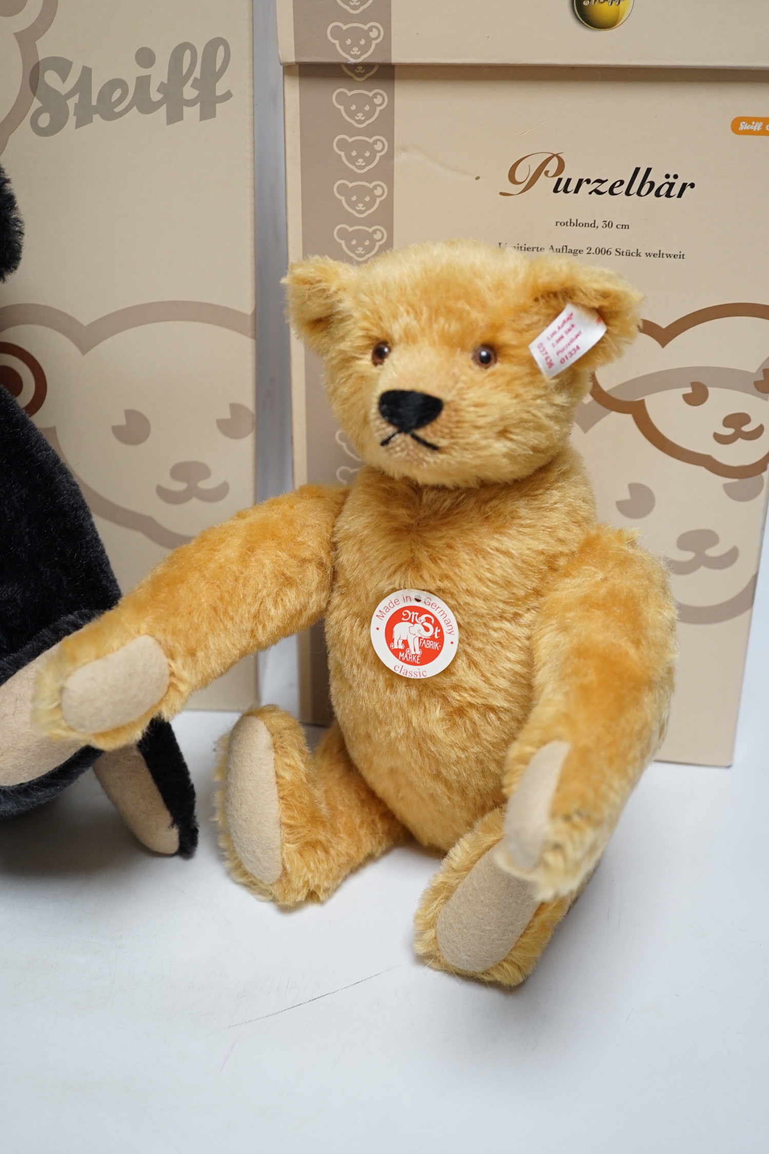 A blond Steiff somersaulting Teddy bear and a Steiff replica 1908 black Teddy bear, each boxed with certificate